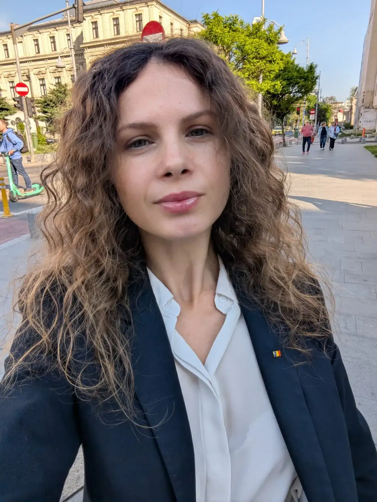 Portret în sacou bleumarin, cu un ac cu tricolorul pe rever
